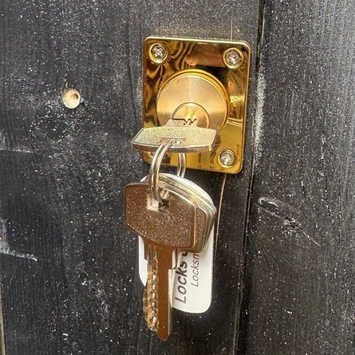 A newly fitted gold lock for southend security gate, with a new set of keys freshly cut hanging from the lock. Including a Locks on Sea pinky red and white key ring.